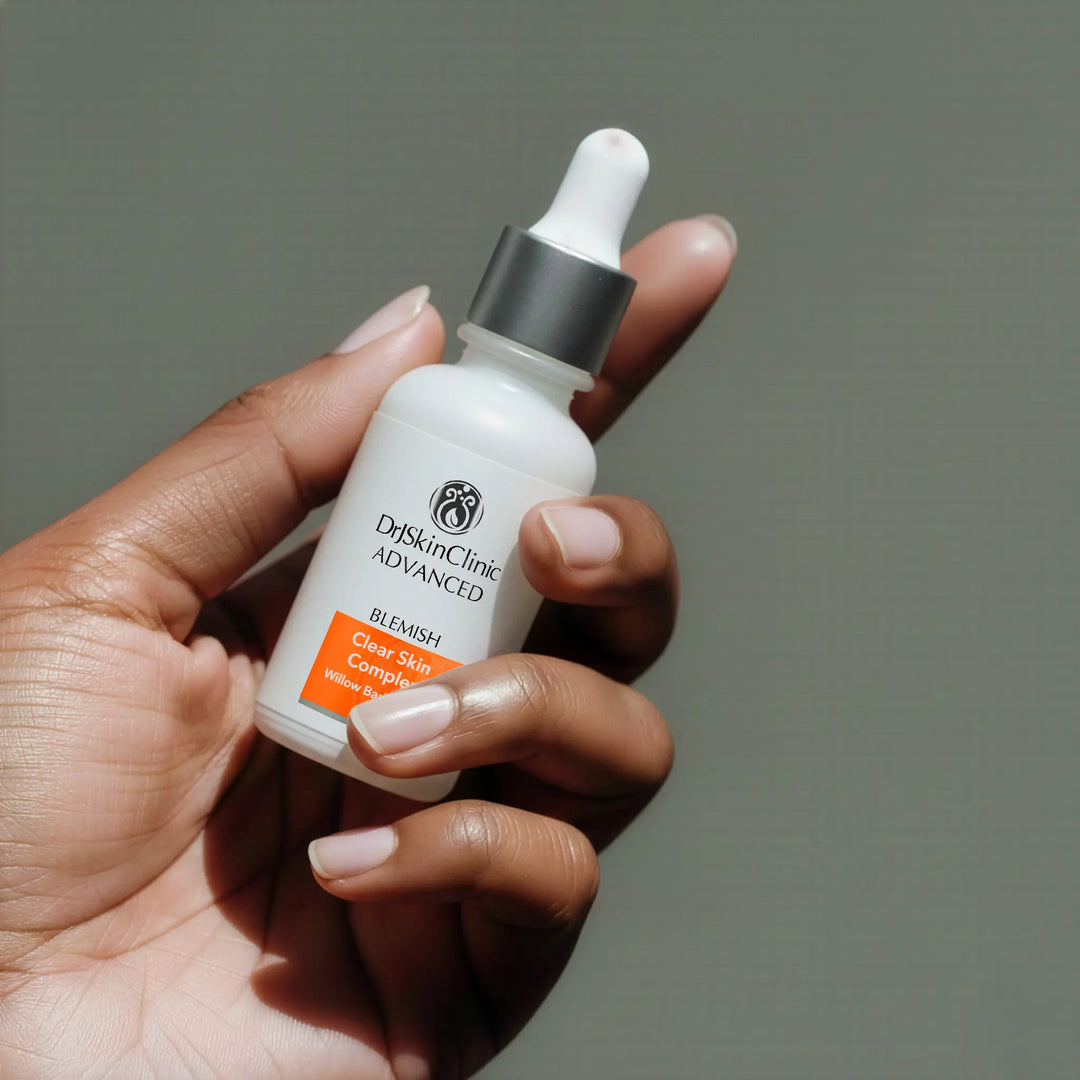 Hand holding DrSkinClinic Advanced Blemish Clear Skin Complex serum with Willow Bark Extract in dropper bottle