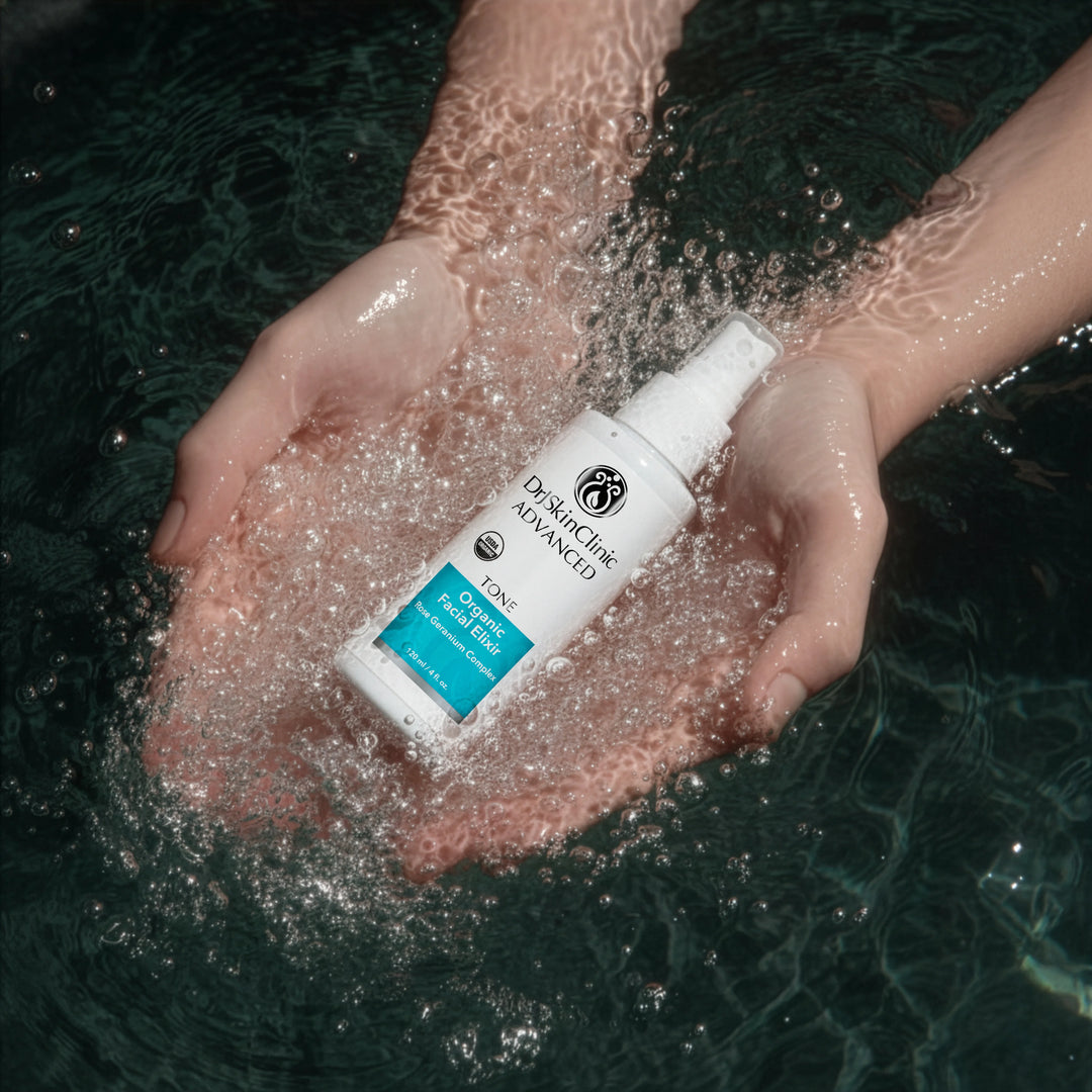 DrJSkinClinic Advanced Tone Organic Facial Elixir held in hands surrounded by water, highlighting refreshing USDA Organic facial toner with Rose Geranium Complex